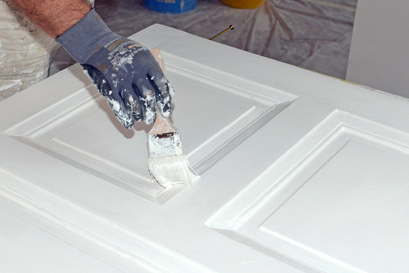 Ein Maler lackiert eine Tür