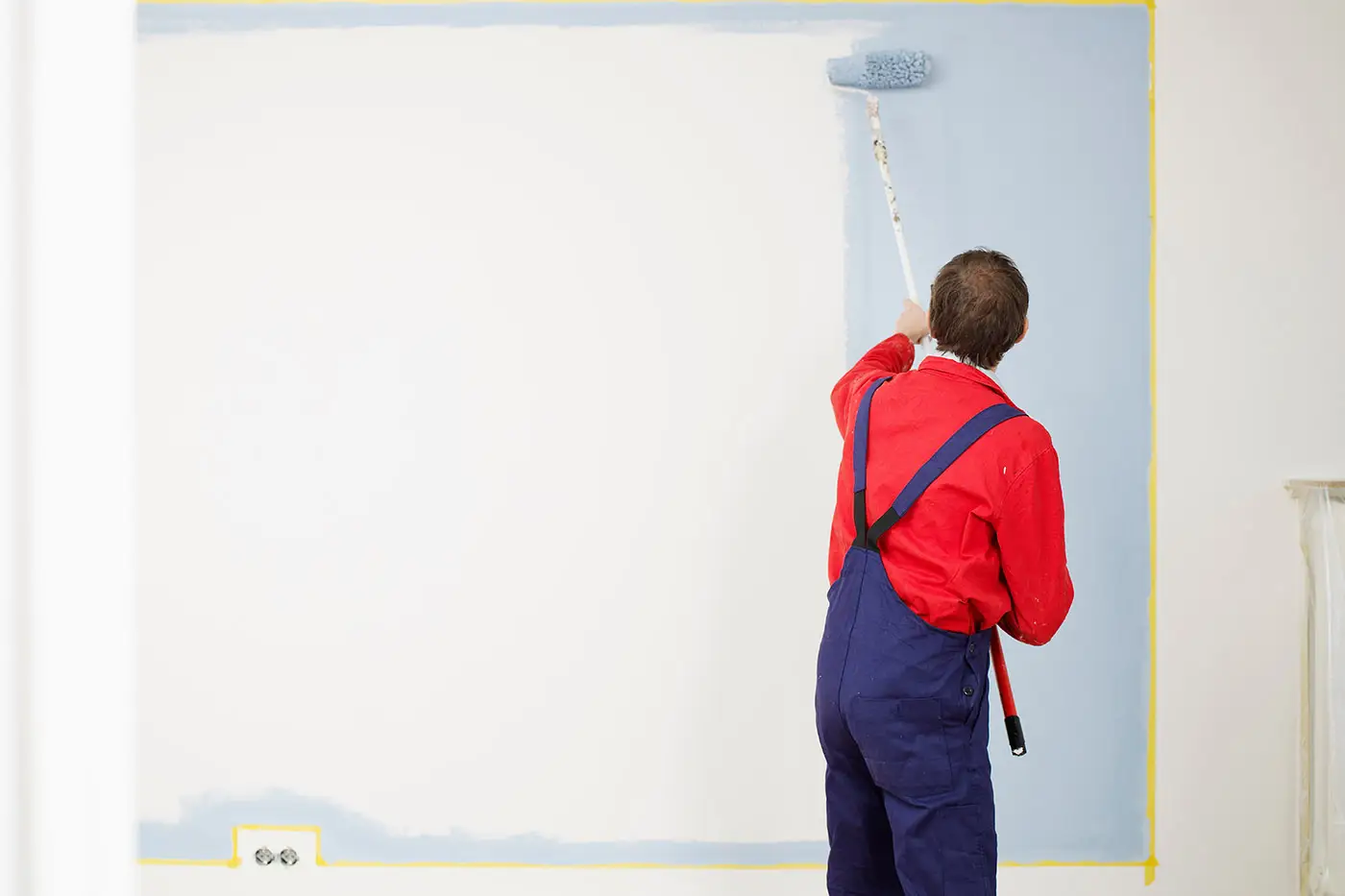 Ein Maler streicht eine Wand