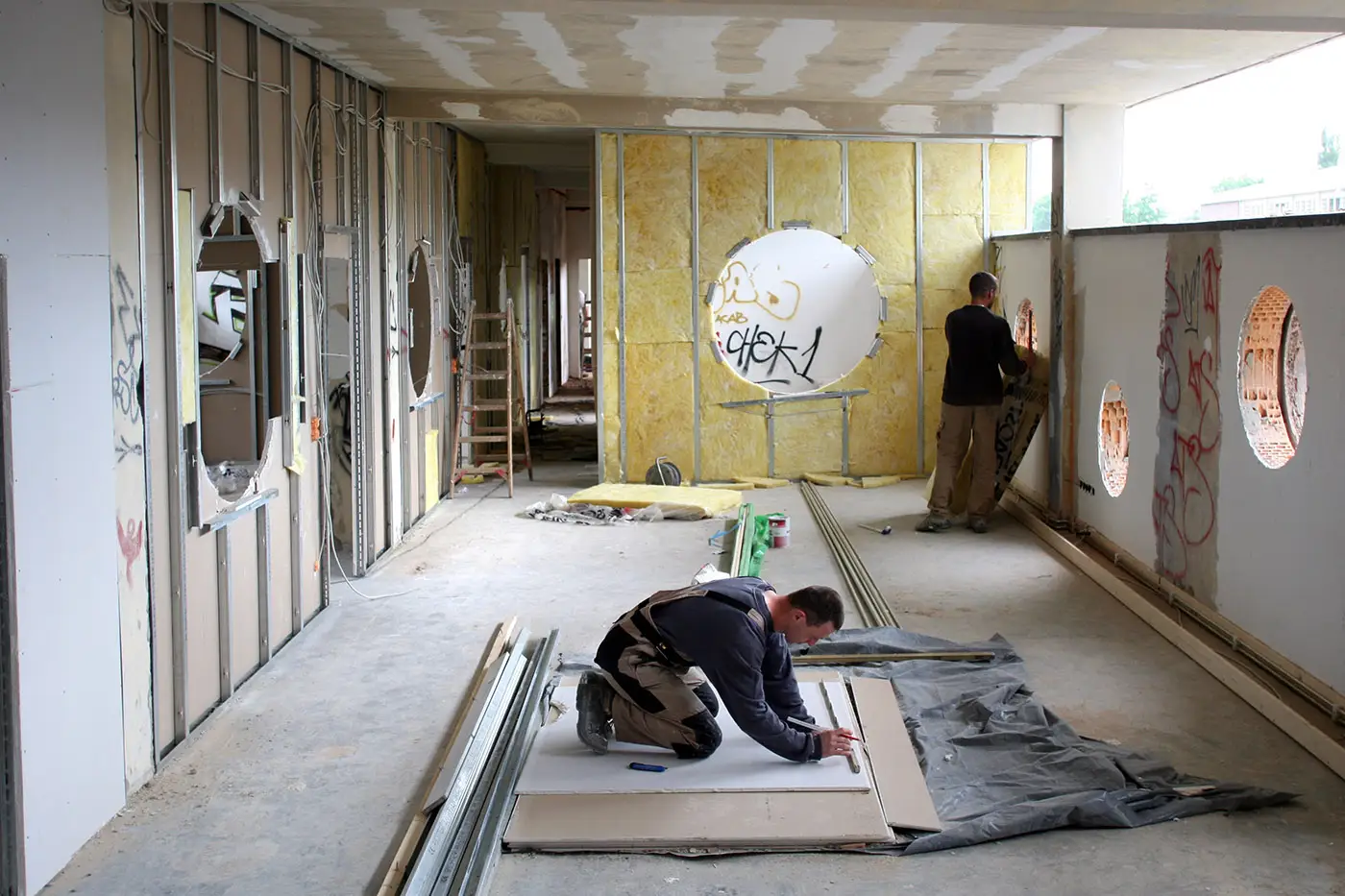 Arbeiter bei Trockenbauarbeiten in einem Gewerbebau