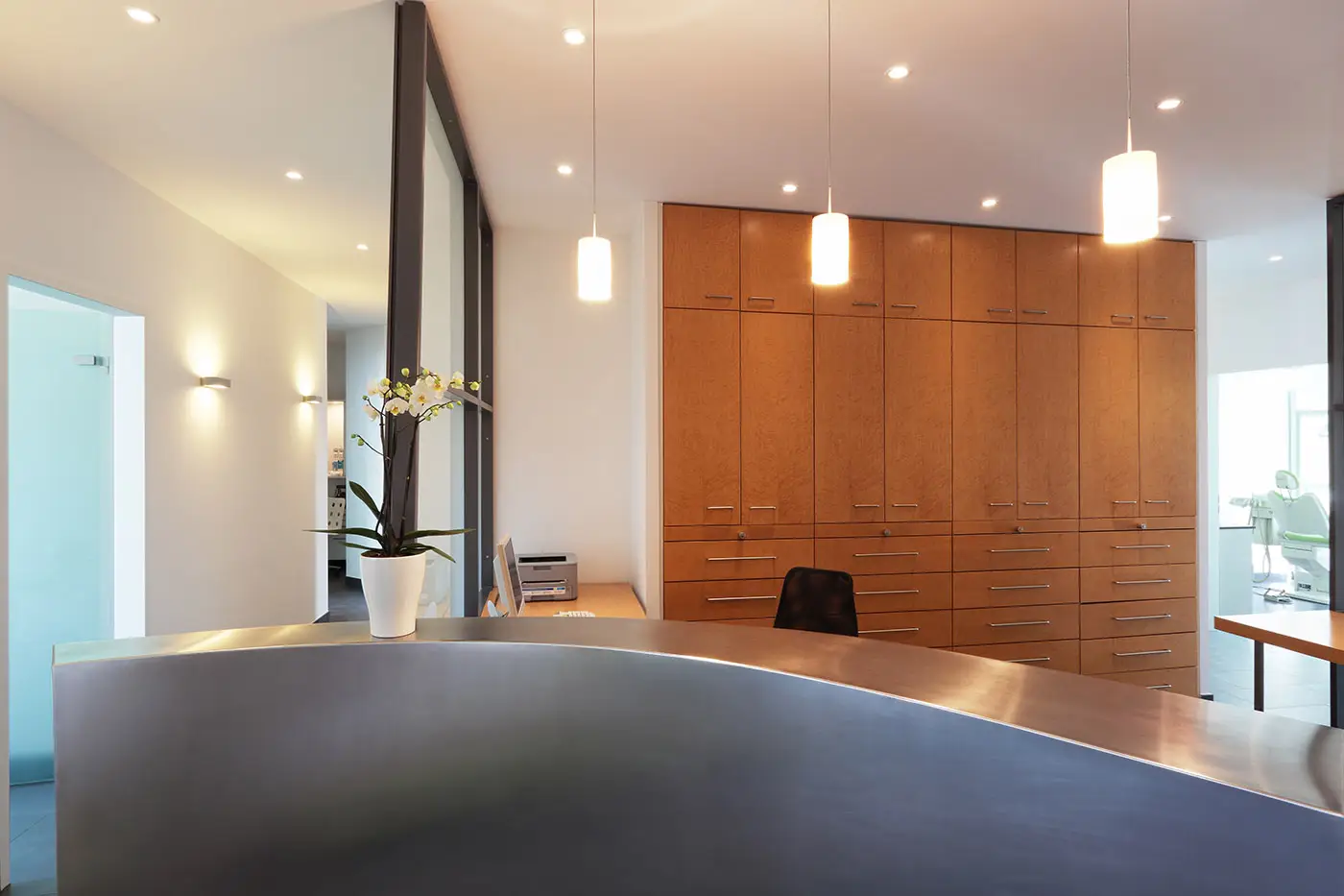 Ein moderner Empfangsbereich mit Wandschränken, Glastrennwand und Empfangstheke