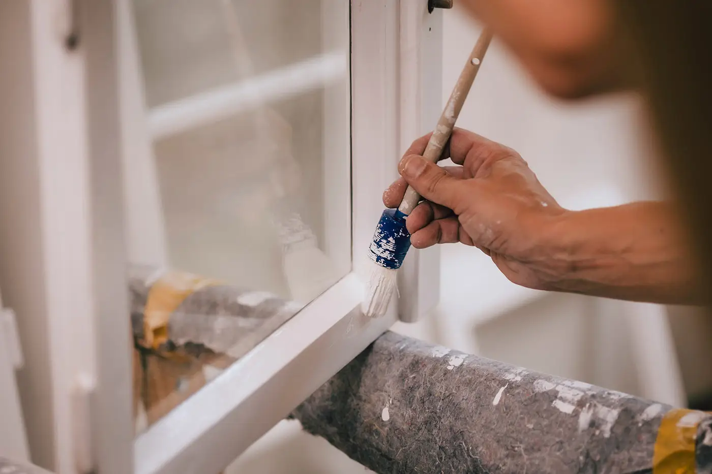 Ein Arbeiter beim Lackieren eines Fensters