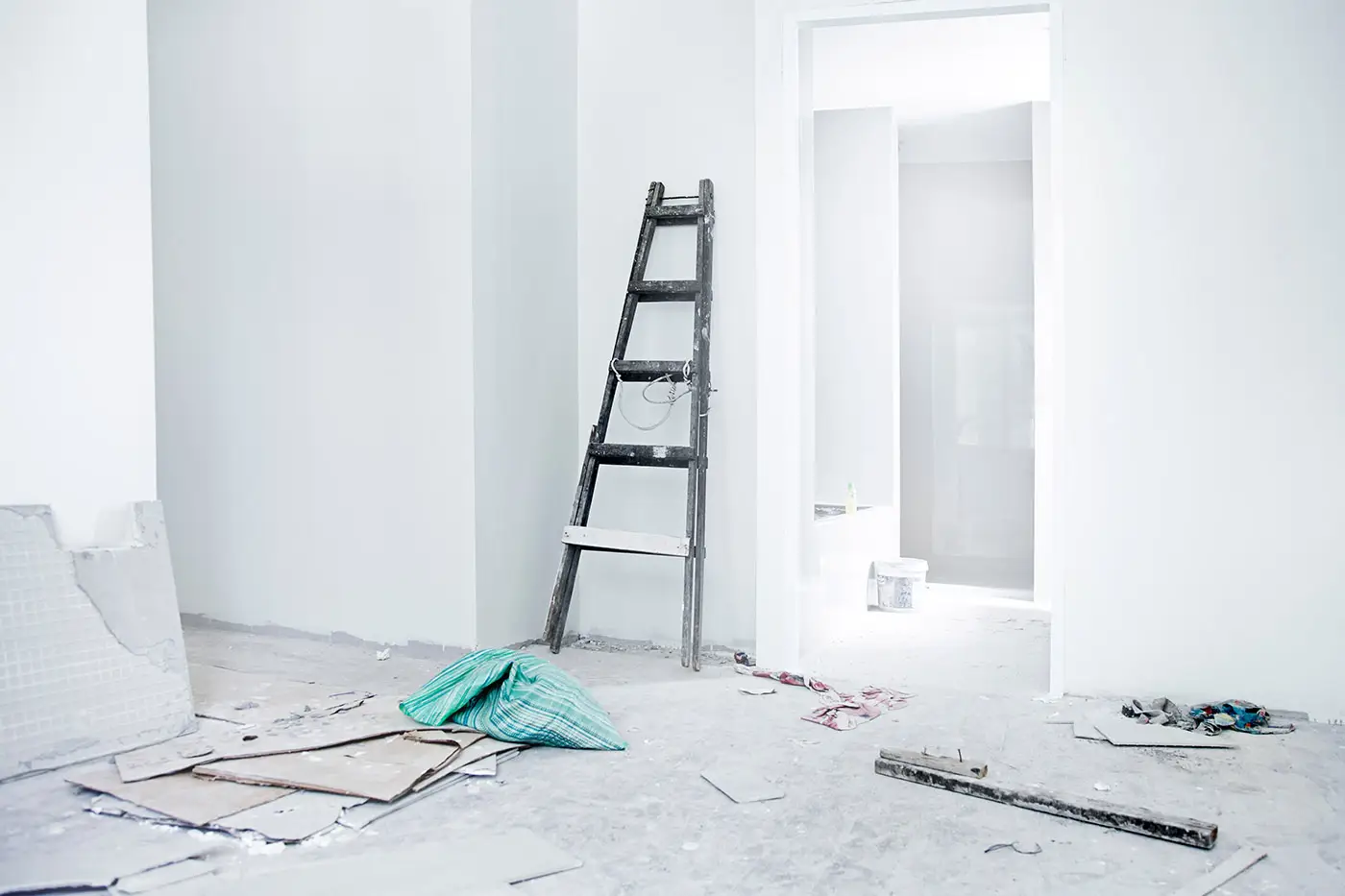 Eine Leiter lehnt an einer frisch renovierten weißen Wand