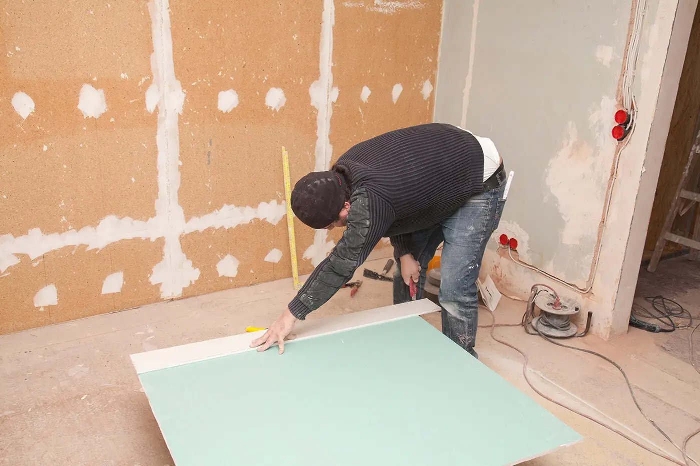 Ein Arbeiter beim Zuschnitt von Platten für Trockenbau