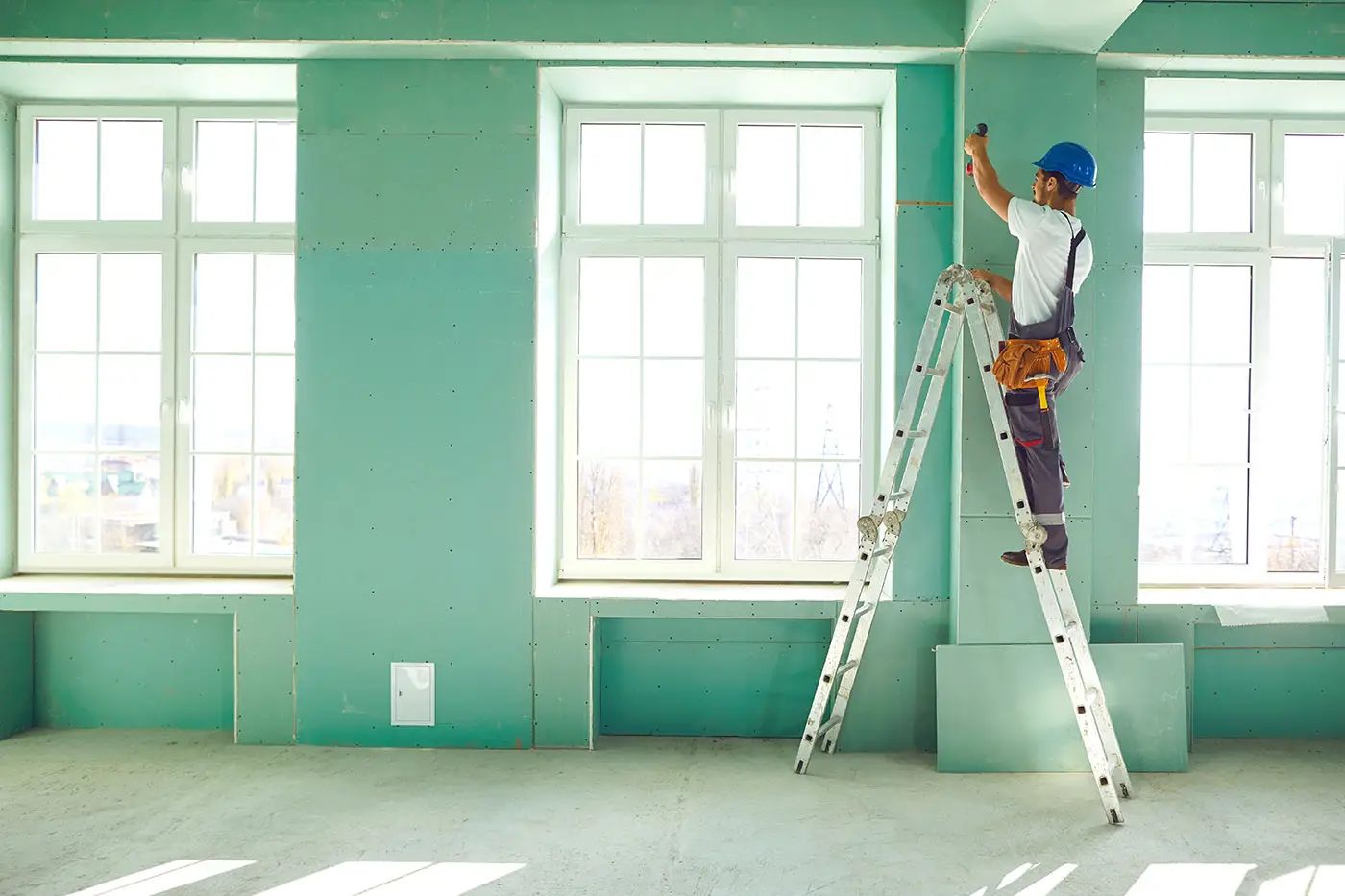 Ein Arbeiter auf der Leiter in einem Gewerberaum