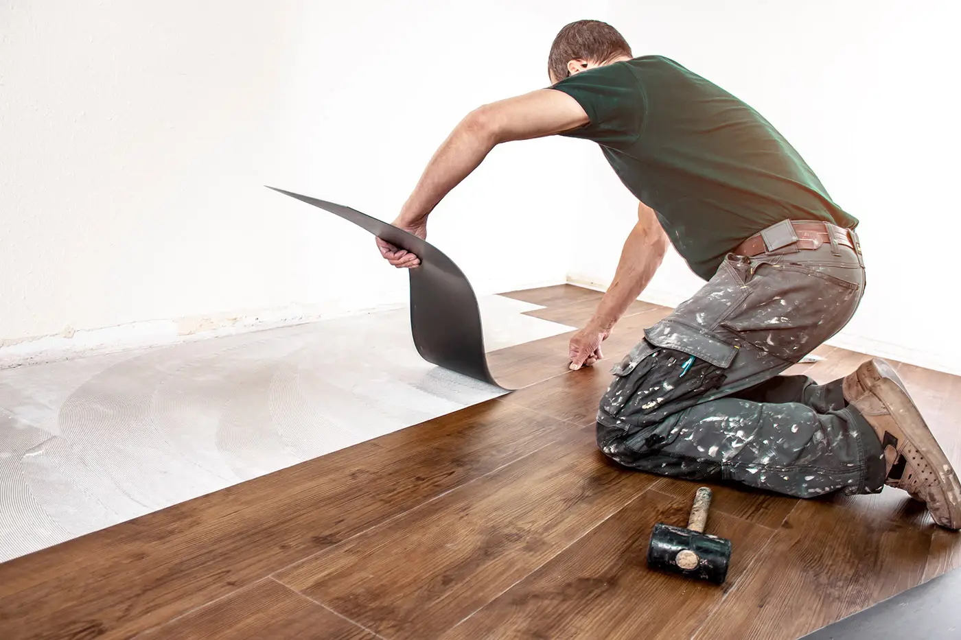 Ein Arbeiter bei der Verlegung von Vinylboden