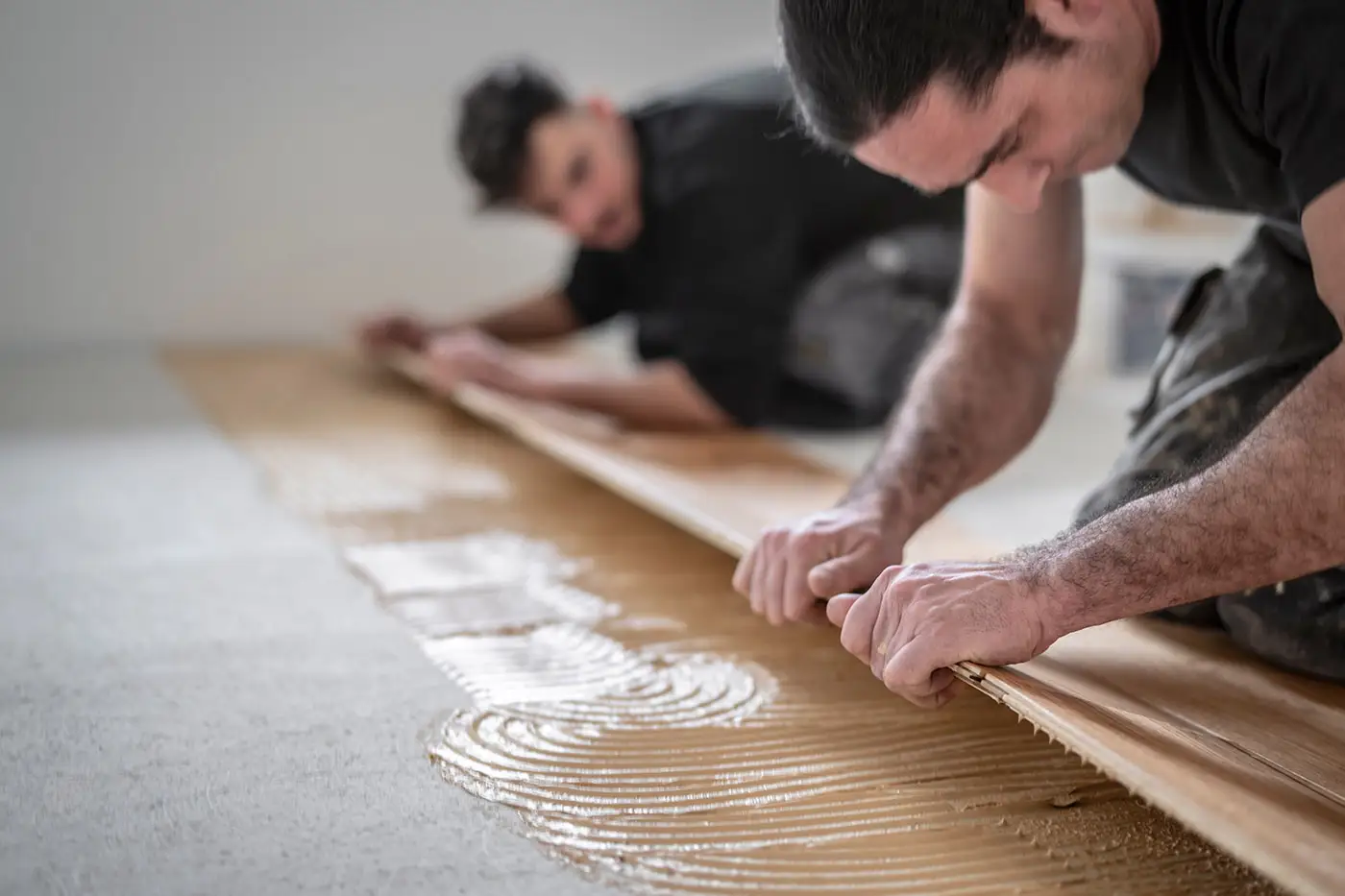 Zwei Arbeiter bei der Verlegung von Laminatboden
