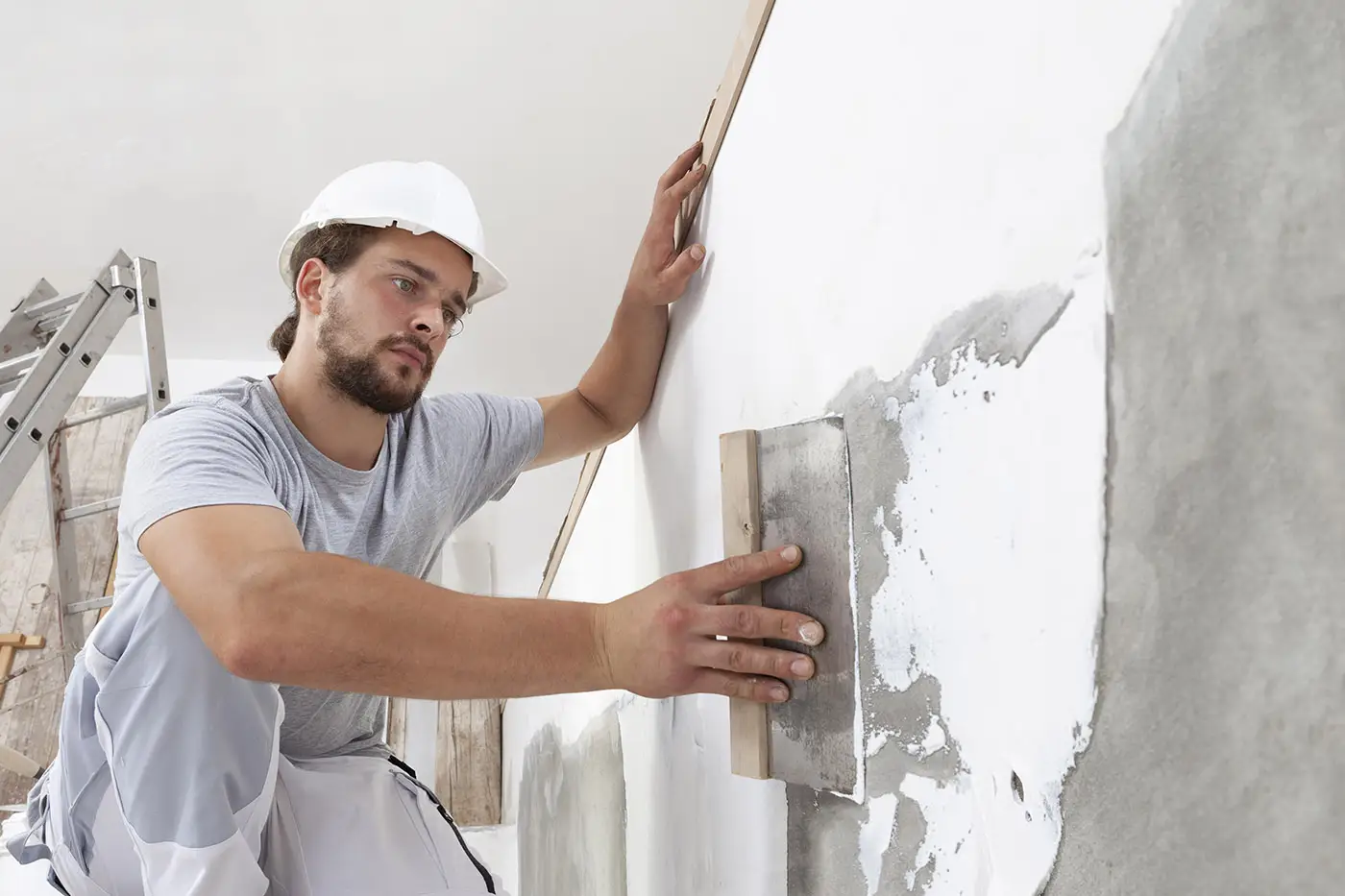 Spachteln eines Treppenaufgangs im Rahmen von Renovierungsarbeiten