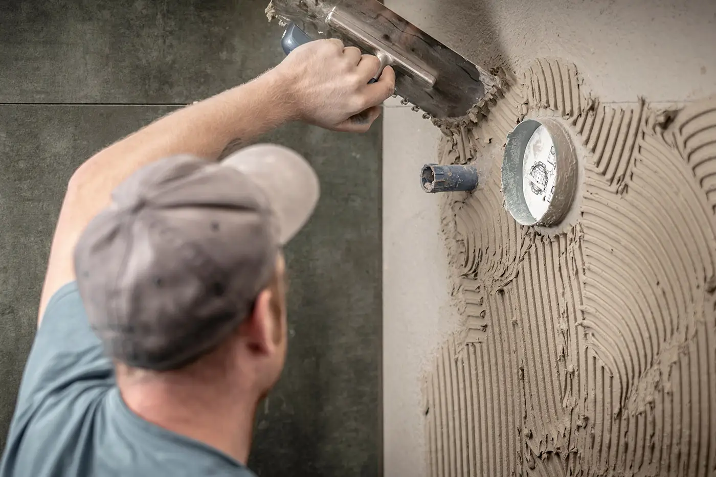 Wasserrohre und Wasseruhr in einem Bad werden verspachtelt
