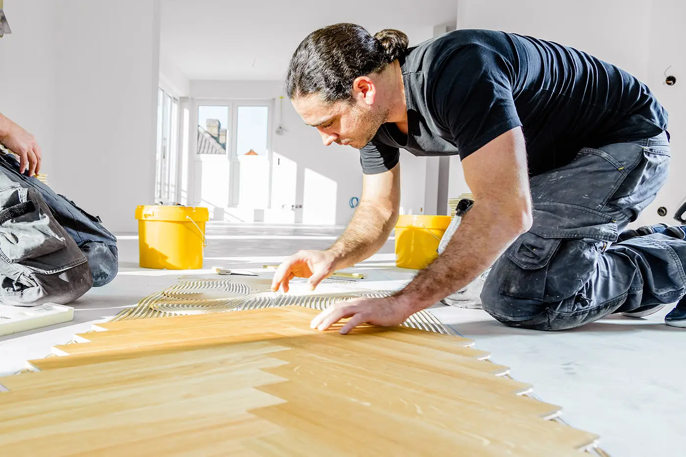 Ein Arbeiter bei der Verlegung von Laminatboden